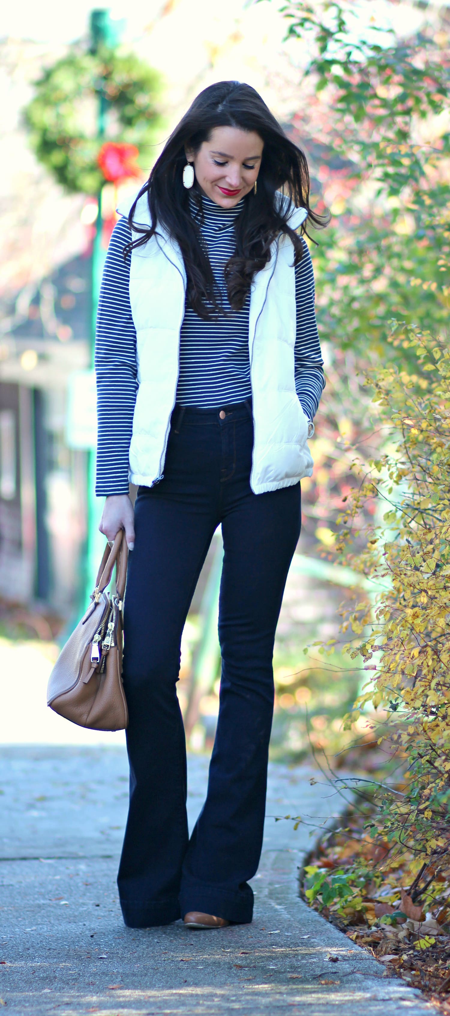 Cute and preppy fall outfit idea with J Brand dark wash flare jeans, Old Navy white puffer vest, and LL Bean striped turtleneck
