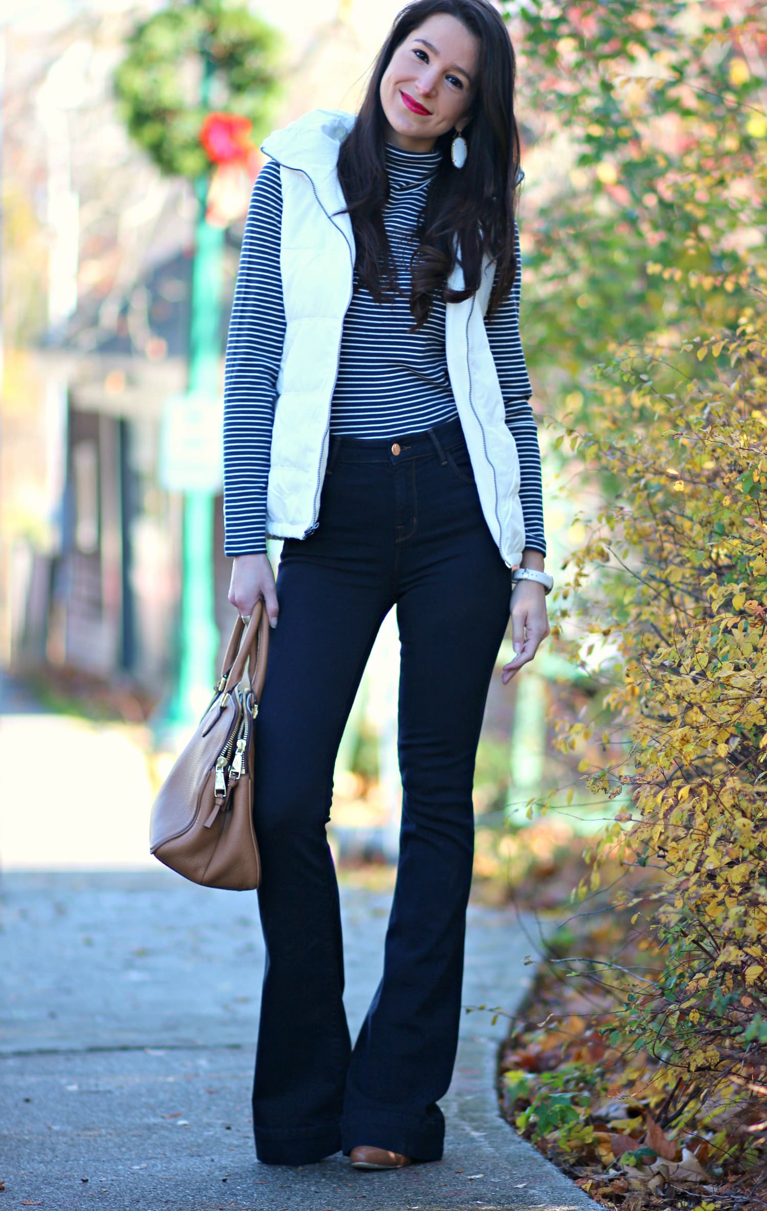 Cute and preppy fall outfit idea with J Brand dark wash flare jeans, Old Navy white puffer vest, and LL Bean striped turtleneck