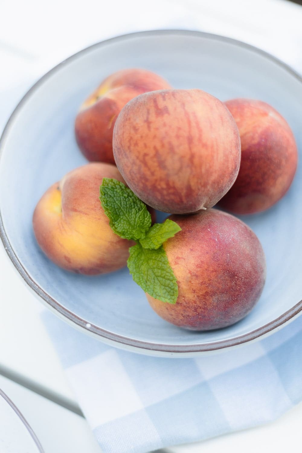 Fresh peaches in a blue bowl on Diary of a Debutante