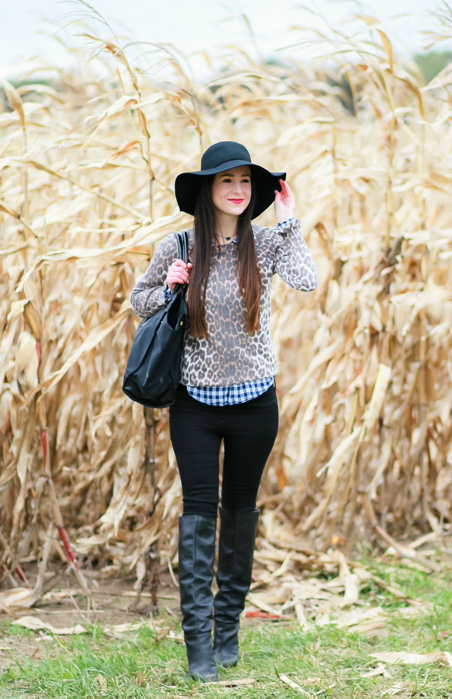 Black floppy hat with leopard crewneck sweater, J.Crew Factory blue gingham button down, black jeans, Nine West tall black boots, and a Tory Burch Ella tote | Comfy and casual fall outfit idea | How to wear a floppy hat in the fall by fashion blogger Stephanie Ziajka from Diary of a Debutante