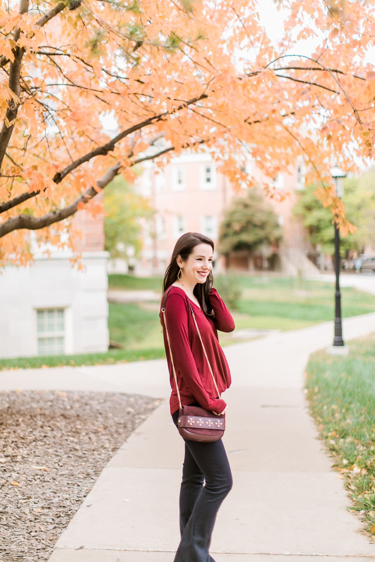Long sleeve burgundy surplice top with dark wash flare jeans | Casual Thanksgiving outfit idea | What to Wear Out on Thanksgiving Eve by fashion blogger Stephanie Ziajka from Diary of a Debutante