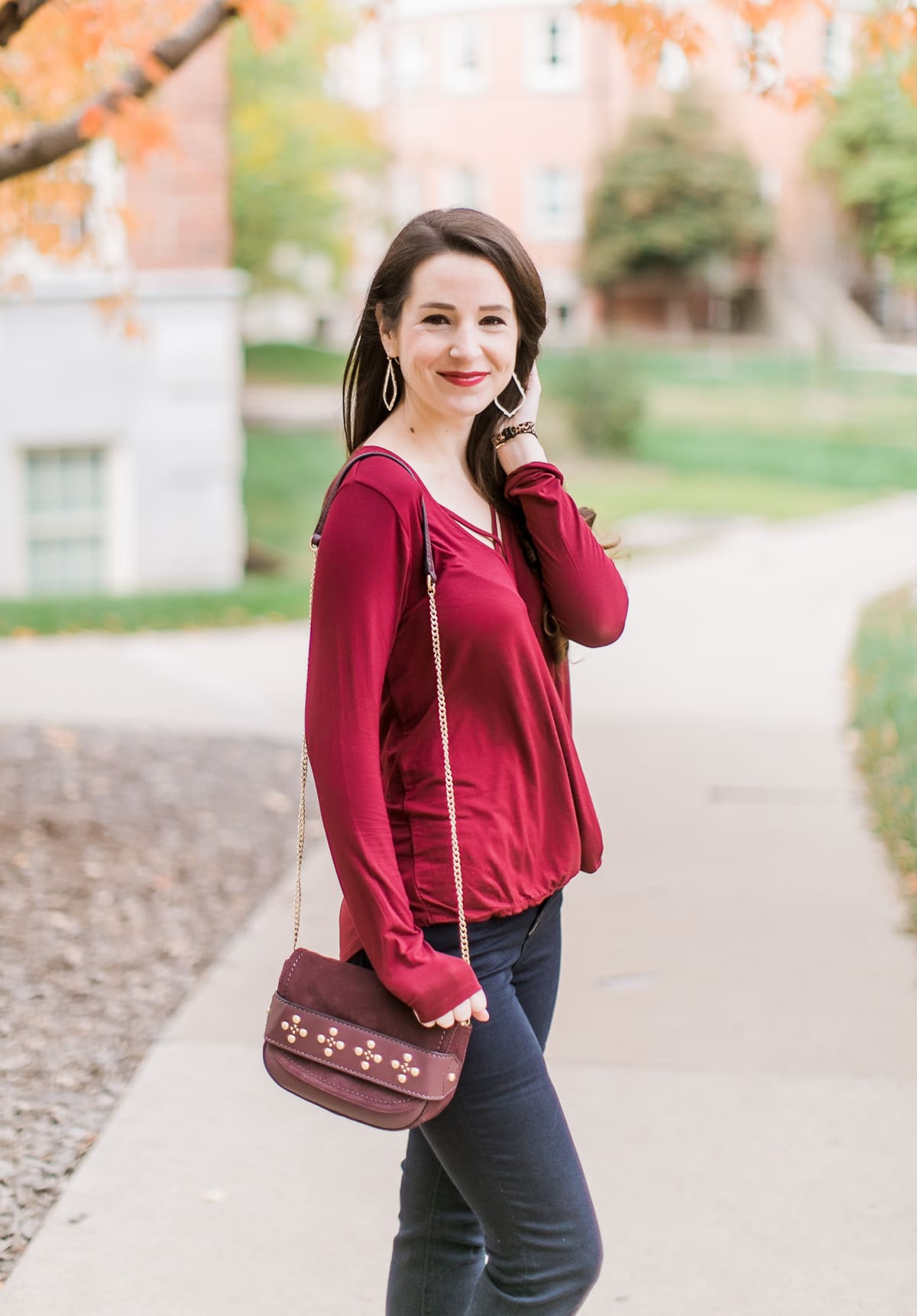 Long sleeve burgundy surplice top with dark wash flare jeans | Casual Thanksgiving outfit idea | What to Wear Out on Thanksgiving Eve by fashion blogger Stephanie Ziajka from Diary of a Debutante