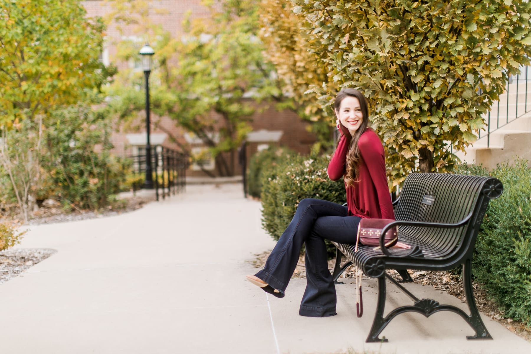 Long sleeve burgundy surplice top with dark wash flare jeans | Casual Thanksgiving outfit idea | What to Wear Out on Thanksgiving Eve by fashion blogger Stephanie Ziajka from Diary of a Debutante