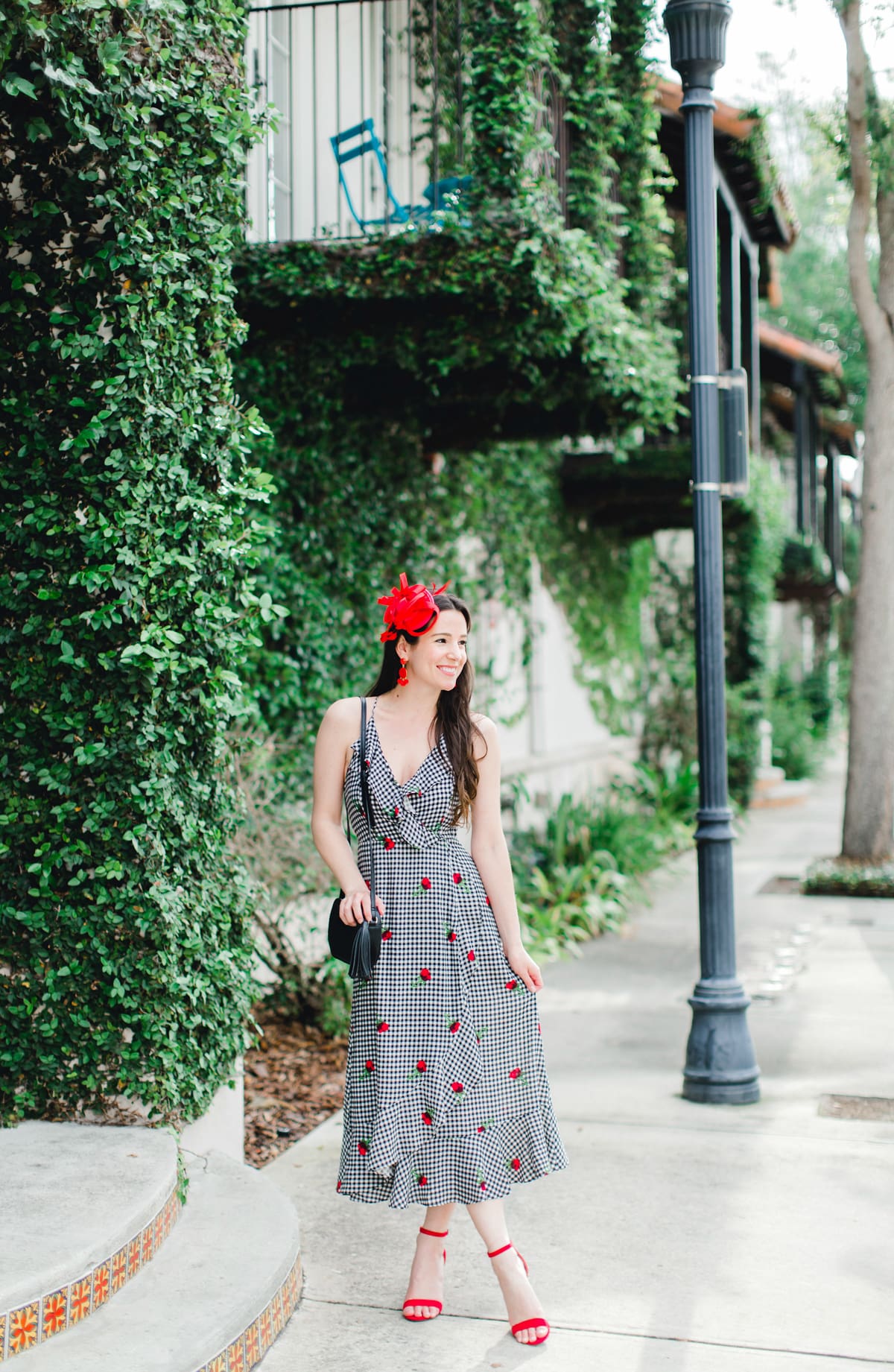What to Wear on Derby Day: 5 Derby-Approved Outfit Ideas by southern fashion blogger Stephanie Ziajka from Diary of a Debutante, derby day fashion rules, derby day fascinators online, how to wear derby day fascinator, derby day dress code, black and white Kentucky Derby dress with affordable red fascinator, red open toe sandals, red drop bead tassel earrings, and black crossbody bag