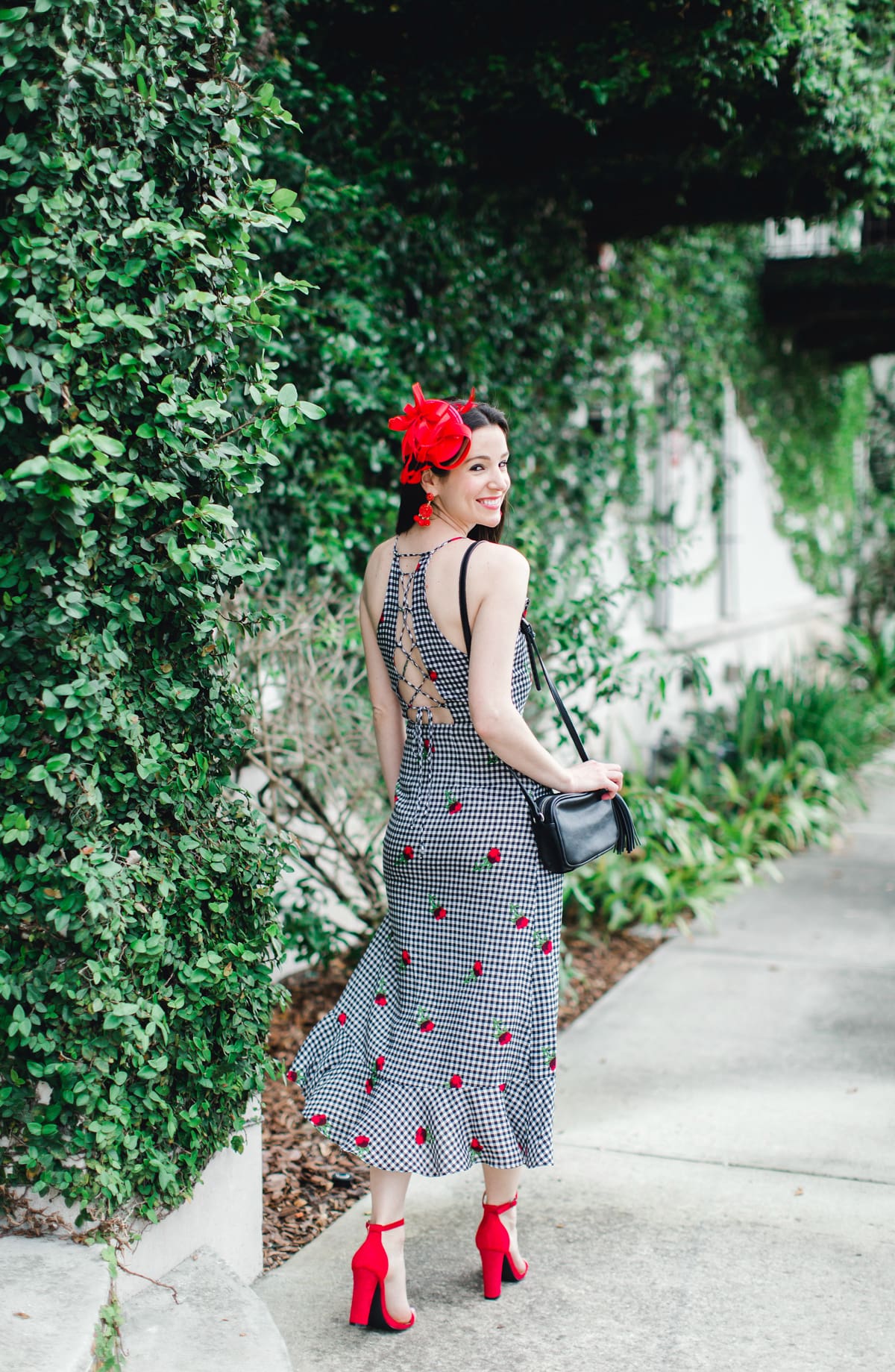 What to Wear on Derby Day: 5 Derby-Approved Outfit Ideas by southern fashion blogger Stephanie Ziajka from Diary of a Debutante, derby day fashion rules, derby day fascinators online, how to wear derby day fascinator, derby day dress code, black and white Kentucky Derby dress with affordable red fascinator, red open toe sandals, red drop bead tassel earrings, and black crossbody bag