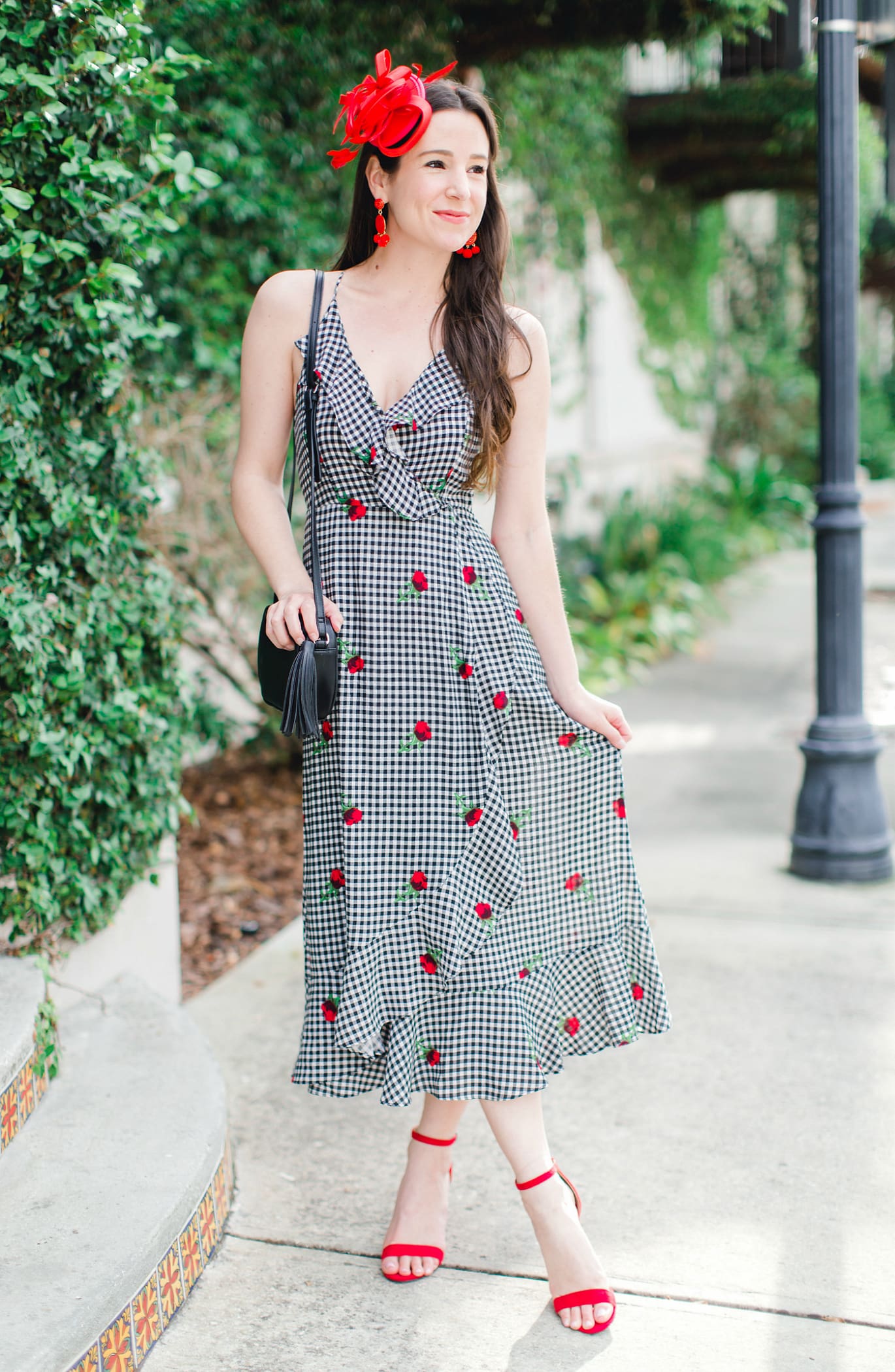 What to Wear on Derby Day: 5 Derby-Approved Outfit Ideas by southern fashion blogger Stephanie Ziajka from Diary of a Debutante, derby day fashion rules, derby day fascinators online, how to wear derby day fascinator, derby day dress code, black and white Kentucky Derby dress with affordable red fascinator, red open toe sandals, red drop bead tassel earrings, and black crossbody bag