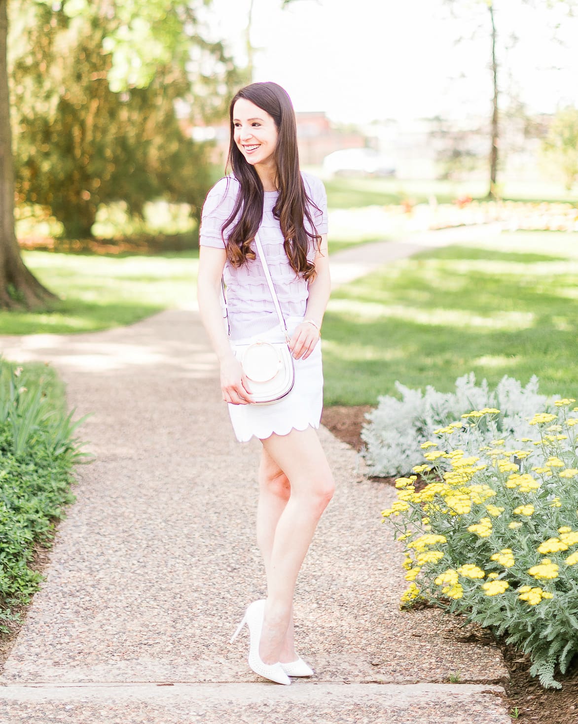 How to wear a short sleeve sweater in the spring by southern fashion blogger Stephanie Ziajka from Diary of a Debutante, lilac Cable Stitch short sleeve sweater, Lilly Pulitzer scalloped mini skirt, white Chloe Nile dupe bag, Chloe dupe bags, Kendra Scott mixed metal bangle set