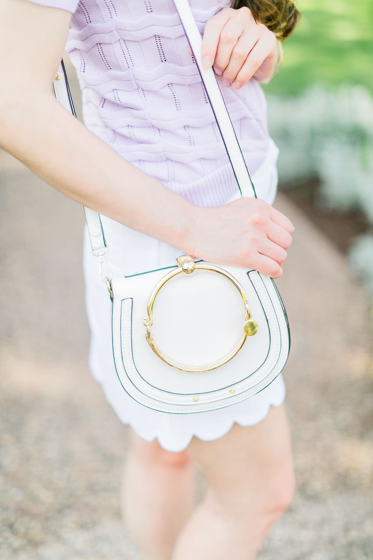 How to wear a short sleeve sweater in the spring by southern fashion blogger Stephanie Ziajka from Diary of a Debutante, lilac Cable Stitch short sleeve sweater, Lilly Pulitzer scalloped mini skirt, white Chloe Nile dupe bag, Chloe dupe bags, Kendra Scott mixed metal bangle set