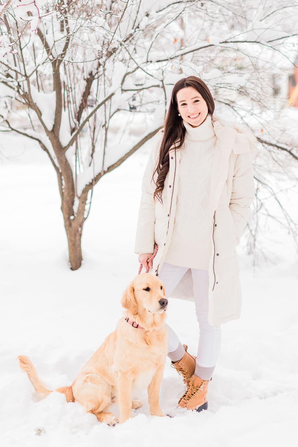 How to Style Bean Boots with the LLBean Ultrawarm Coat by affordable fashion and southern lifestyle blogger Stephanie Ziajka from Diary of a Debutante, LLBean Ultrawarm Coat Three Quarter Length in paperwhite, bean boots style, parka outfit ideas, white sweater outfit, LLBean bean boots styled with LLBean ultrawarm coat, white skinny jeans, and a white oversized turtleneck sweater, golden retriever puppy in the snow