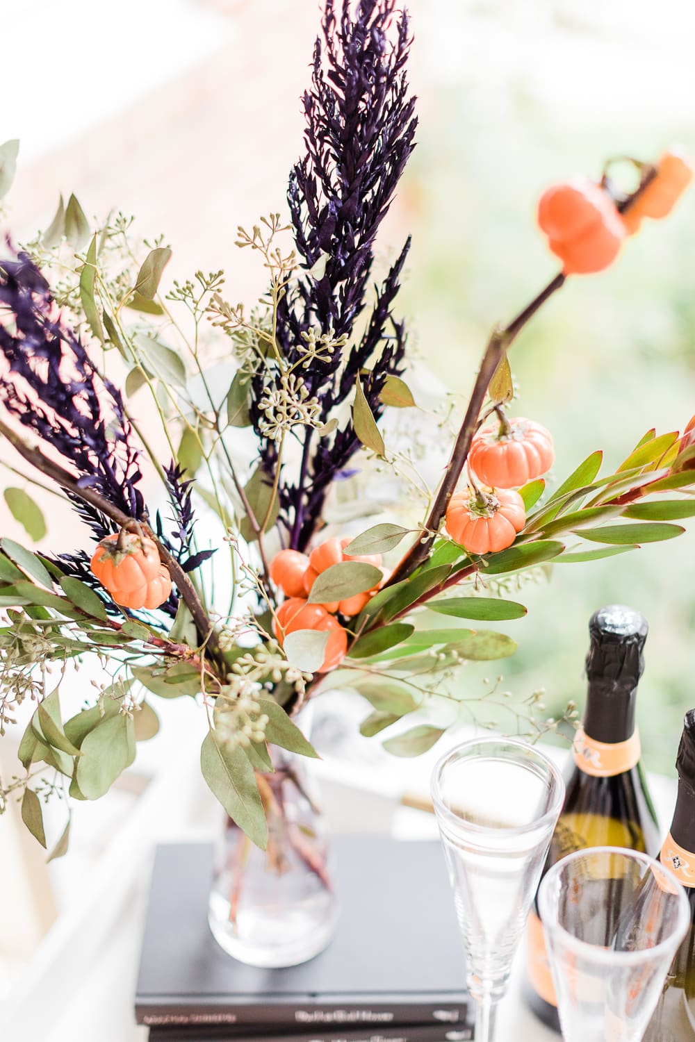 simple Halloween floral arrangement with fresh cut fresh cut pumpkin tree branches, Halloween centerpiece idea, Halloween Bar Cart + DIY Pumpkin Ice Bucket Tutorial by popular affordable fashion blogger Stephanie Ziajka on Diary of a Debutante, Halloween bar cart ideas, how to decorate a halloween bar cart