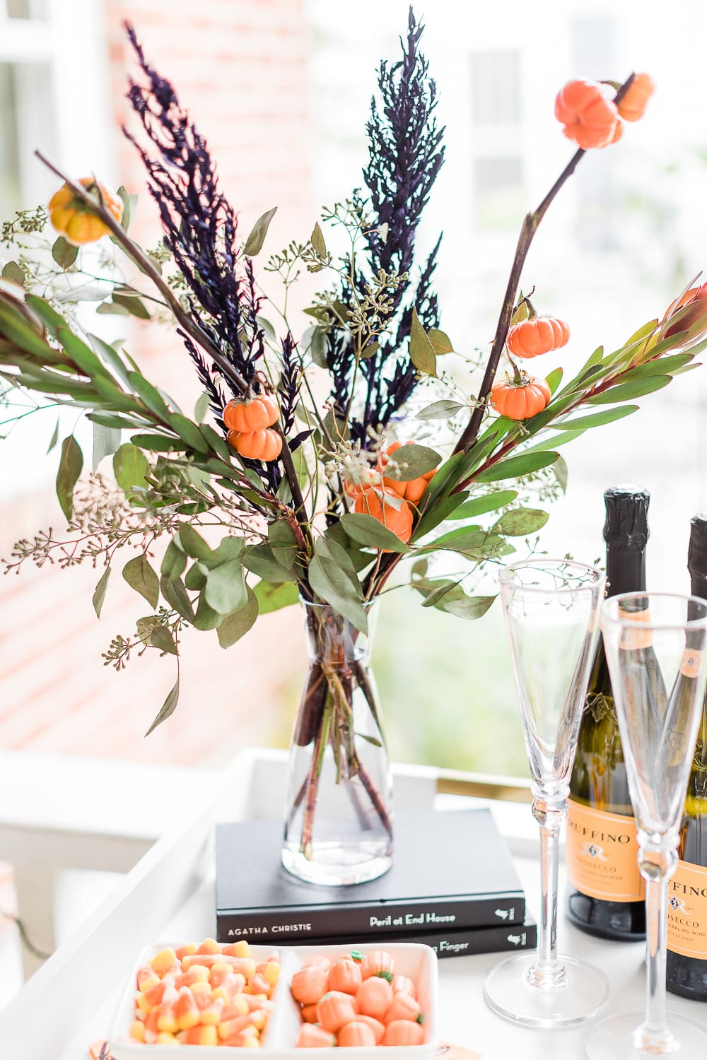 simple Halloween floral arrangement with fresh cut fresh cut pumpkin tree branches, Halloween centerpiece idea, Halloween Bar Cart + DIY Pumpkin Ice Bucket Tutorial by popular affordable fashion blogger Stephanie Ziajka on Diary of a Debutante, Halloween bar cart ideas, how to decorate a halloween bar cart