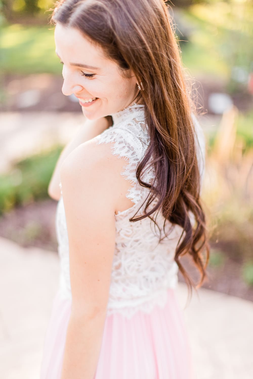 Day to Night: How to Wear a Pink Midi Skirt in the Fall by popular affordable fashion blogger Stephanie Ziajka on Diary of a Debutante, Amazon pink pleated midi skirt styled with an Amazon white lace crop top, white Chloe Nile dupe bag, and pink Nina Cherie dress pumps