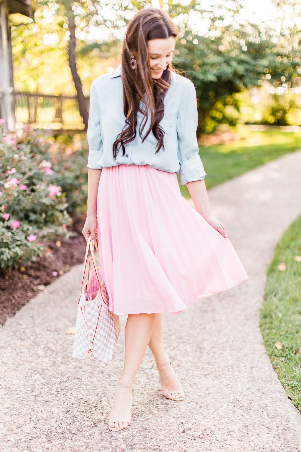 Day to Night: How to Wear a Pink Midi Skirt in the Fall by popular affordable fashion blogger Stephanie Ziajka on Diary of a Debutante, Amazon pink pleated midi skirt styled with SO chambray button down shirt, Amazon nude block heel sandals, and a Louis Vuitton Neverfull dupe bag