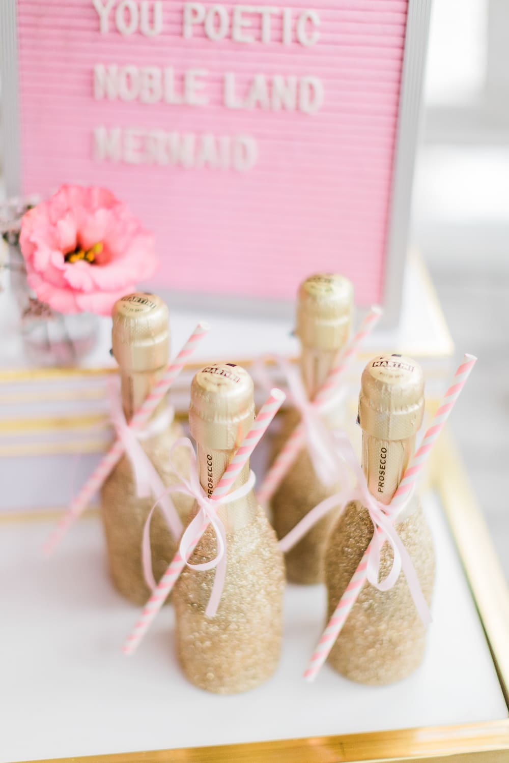 Mini glitter champagne bottles displayed on southern lifestyle blogger Stephanie Ziajka's Galentine's Day bar cart