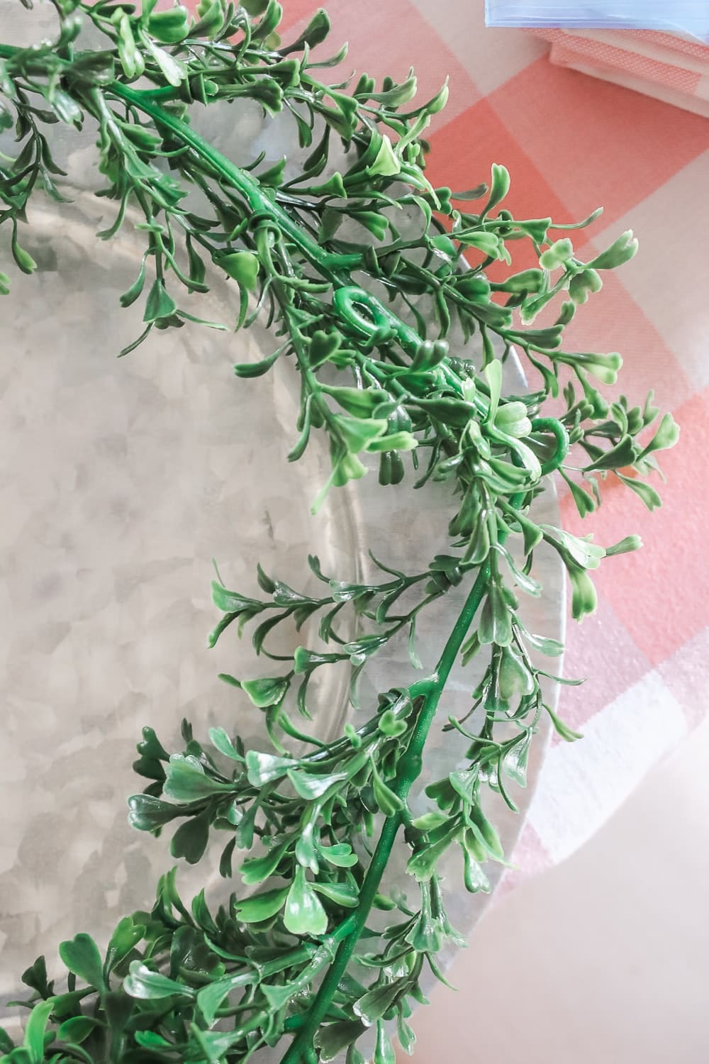 DIY blogger Stephanie Ziajka shows how to make your own unique DIY chargers with only some faux boxwood garland and scissors on Diary of a Debutante