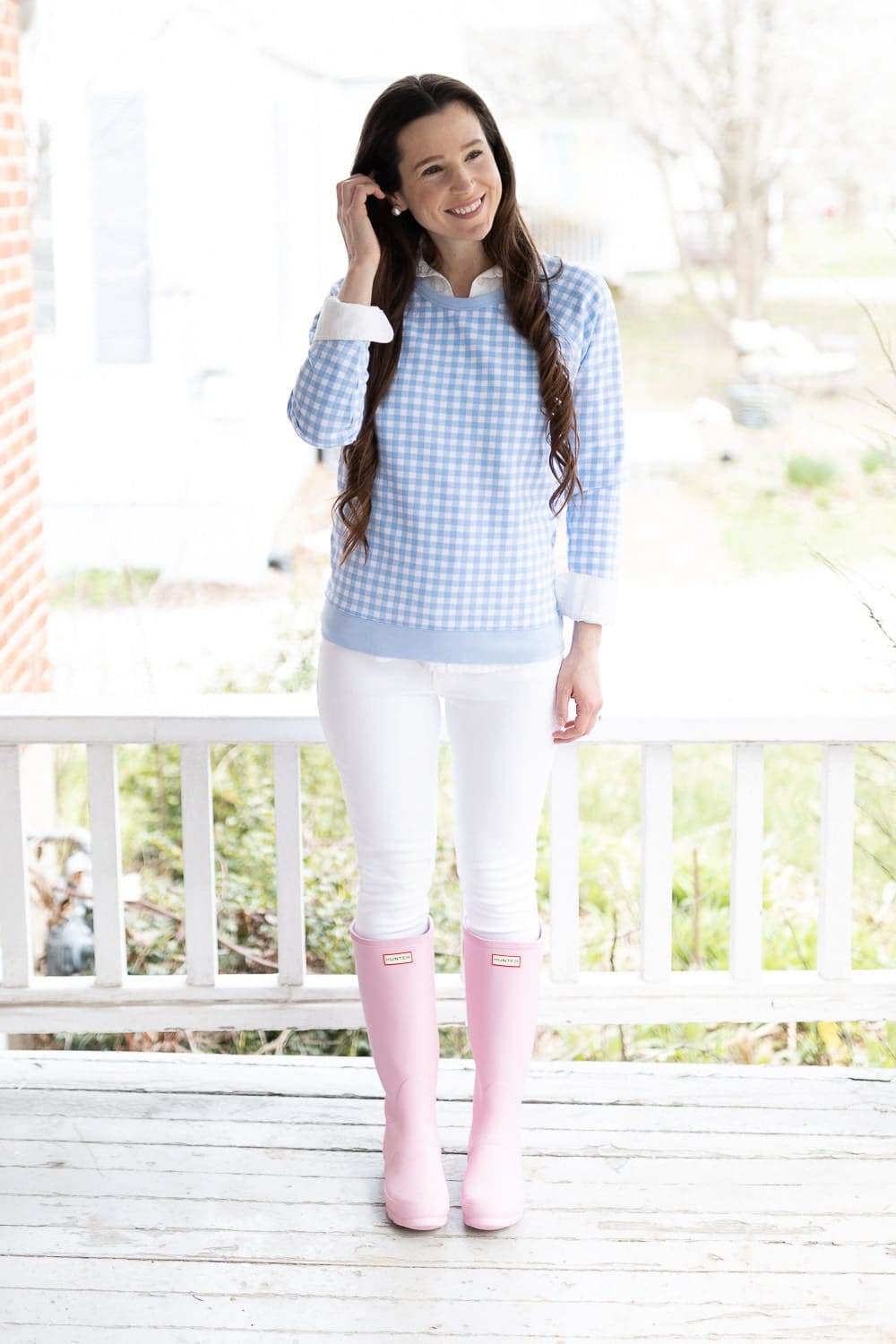 Preppy fashion blogger Stephanie Ziajka styles her pink Hunter boost with a blue gingham Draper James sweater and white skinny jeans on Diary of a Debutante