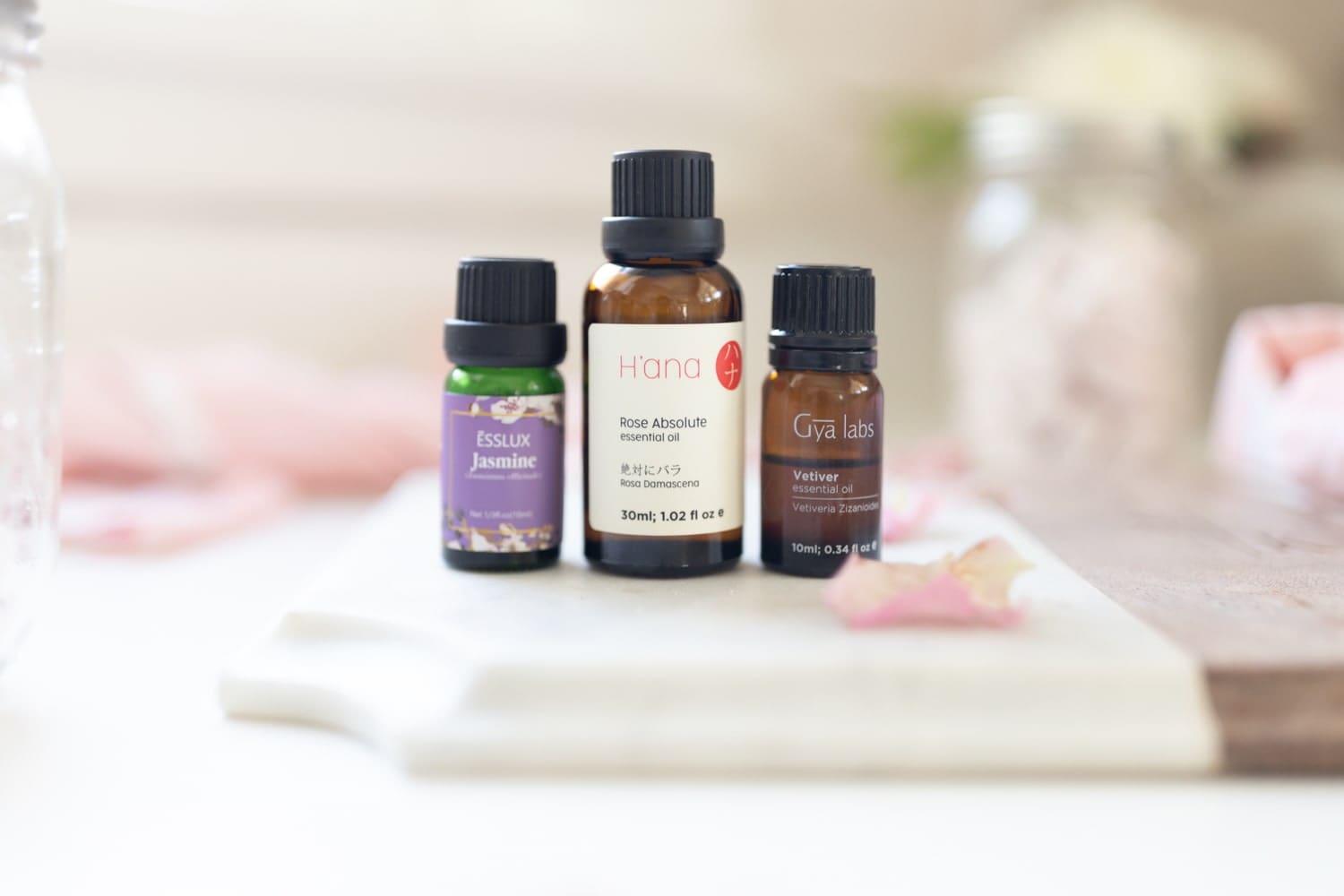 Bottles of rose absolute essential oil, vetiver essential oil, and jasmine essential oil on Diary of a Debutante