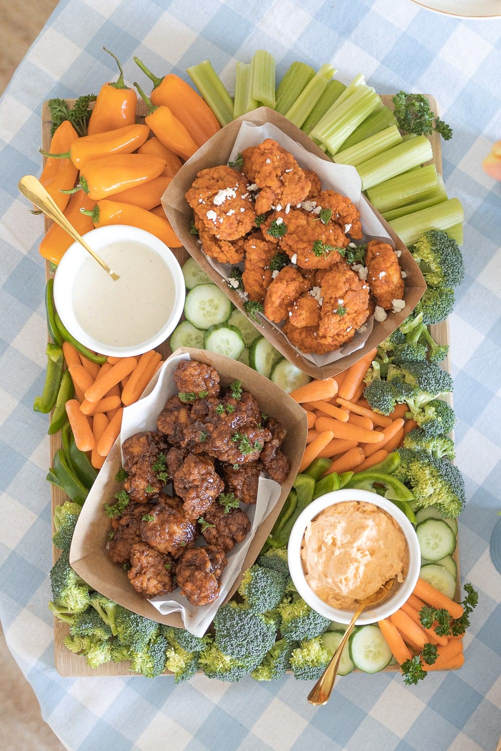 Game Day snack board made with Hy-Vee boneless chicken wings, buffalo chicken dip, ranch dressing, and fresh vegetables by southern lifestyle blogger Stephanie Ziajka on Diary of a Debutante