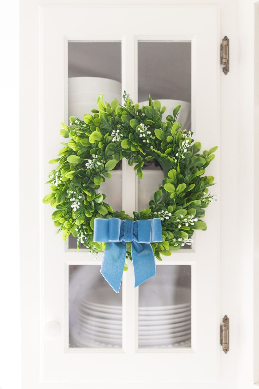 Blue velvet bow on a boxwood wreath on Diary of a Debutante
