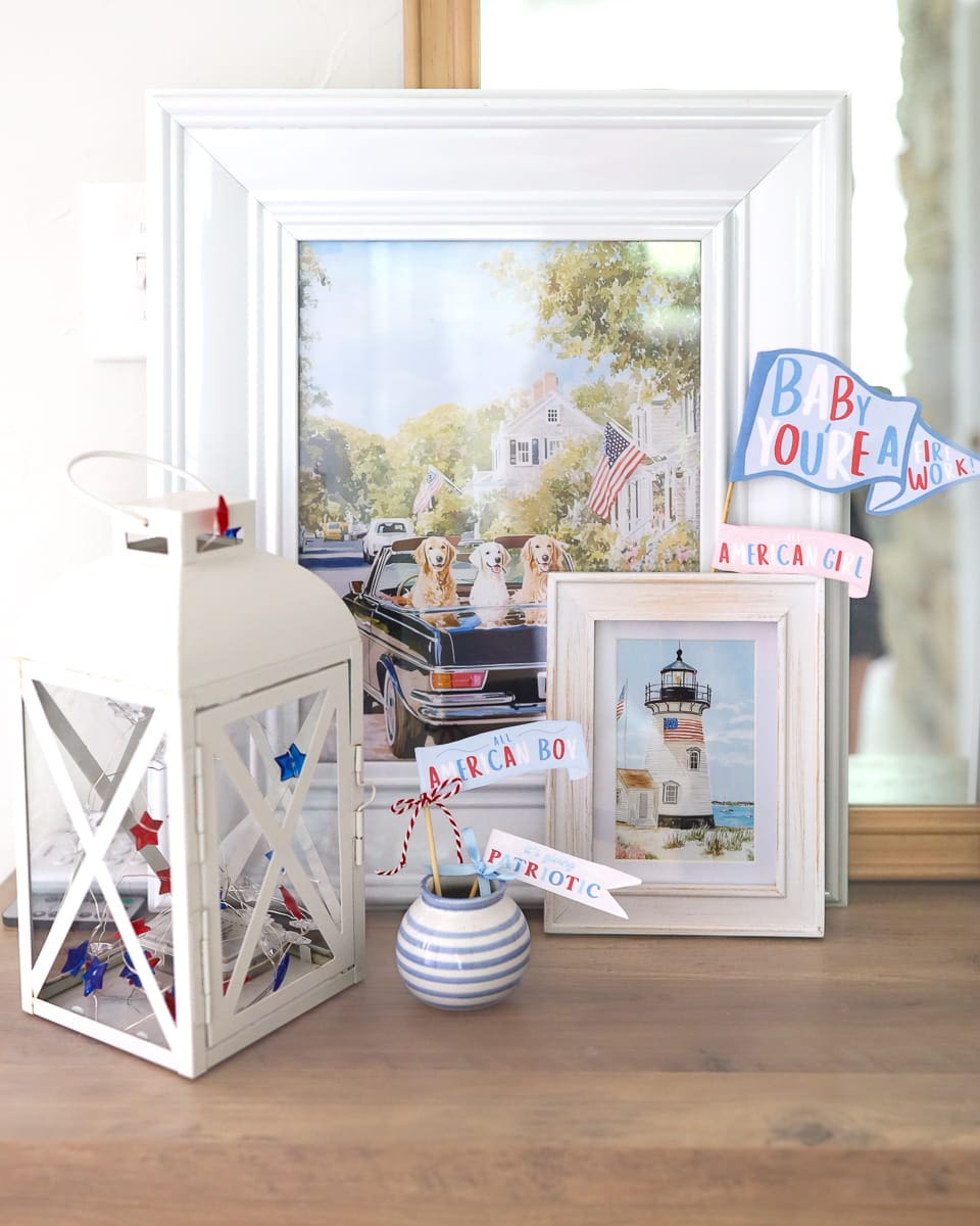 Patriotic mini pennant flags decorating an entryway console table with red, white, and blue summer accents.