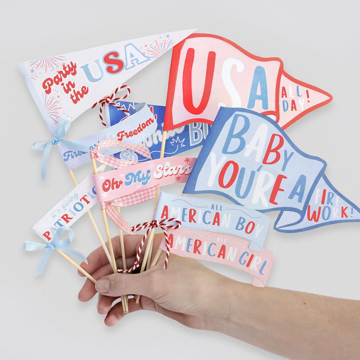 Red, white, and blue patriotic mini pennant flags that can be used as cupcake toppers on a festive 4th of July dessert table, extra color in a 4th of July centerpiece, or added charm to any patriotic decor set-up